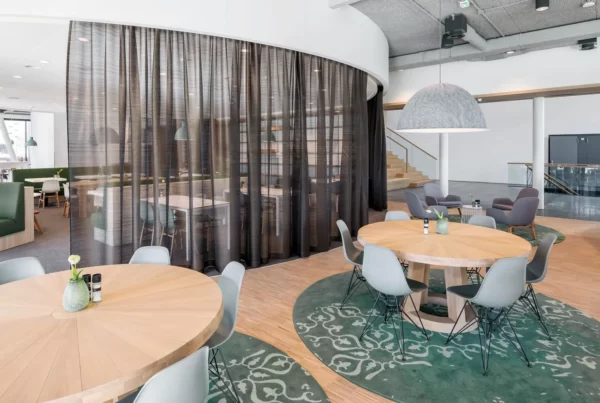 Interieurontwerp werkcafé met rond verlaagd wit plafond en ronde tafels met Vitra stoelen