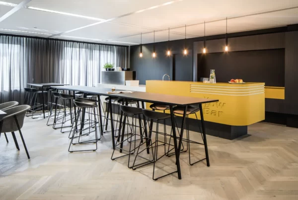 interieurontwerp lunchruimte met yellow bar en zwarte lunchtafels en stoelen