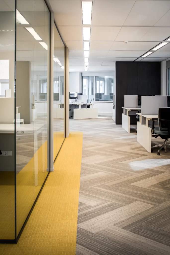 kantoorinrichting met visgraat motief in tapijt en gele vloerbedekking in stilteruimten