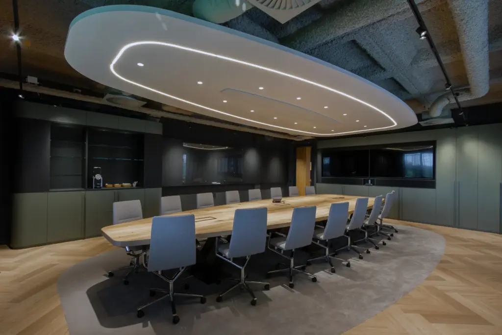 Executive boardroom met geïntegreerde audiovisuele wand en maatwerk interieur