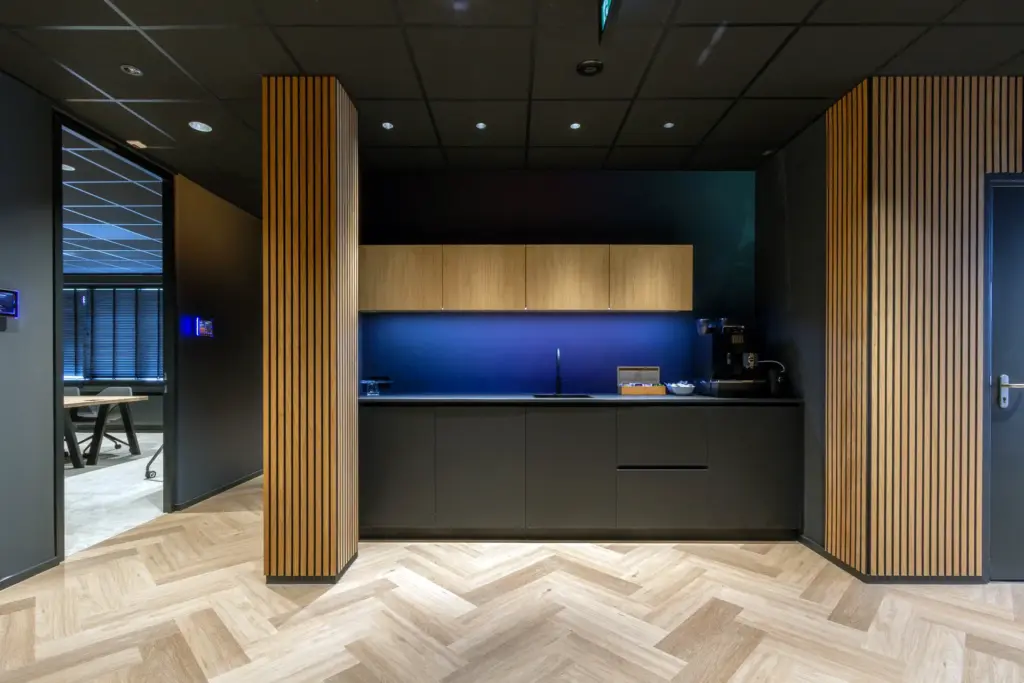 Maatwerk pantry met houten wandafwerking en moderne keuken in kantoorinterieur