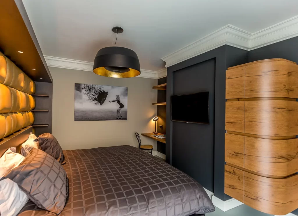 Binnenhuisarchitect ontwerp hotelkamer met ronde kast en luxe bedwand met goudkleurige kussens