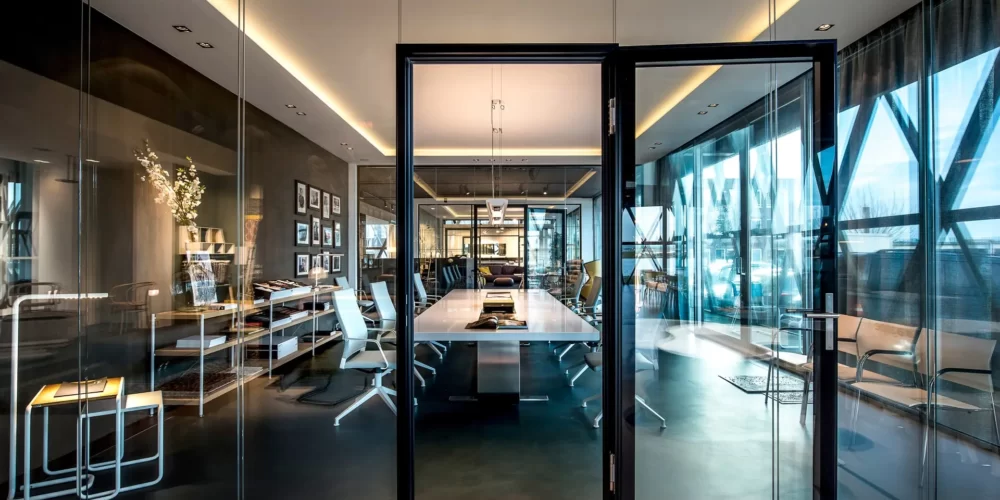 Zwarte kaderwand van dubbelglas in showroom met vergaderruimte en plafondkaders met indirecte verlichting - Interieurarchitect Plamen van Dijk