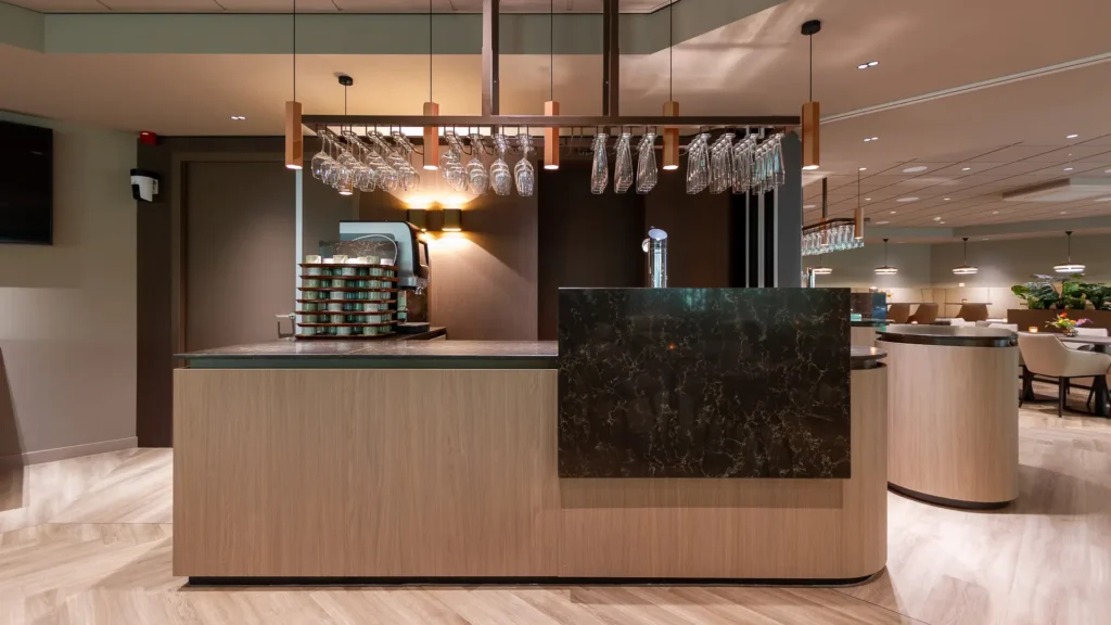 Close‑up van marmeren barfront in Crematorium Venlo met hangende wijn- en waterglazen.