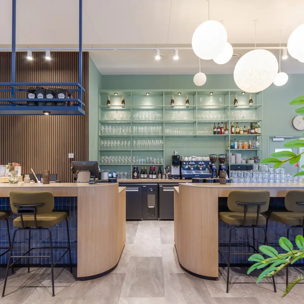 Modern hospitality interieur met maatwerk bar als sociaal middelpunt van het clubhuis, ontworpen door interieurarchitect Plamen van Dijk