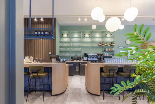 Modern hospitality interieur met maatwerk bar als sociaal middelpunt van het clubhuis, ontworpen door interieurarchitect Plamen van Dijk